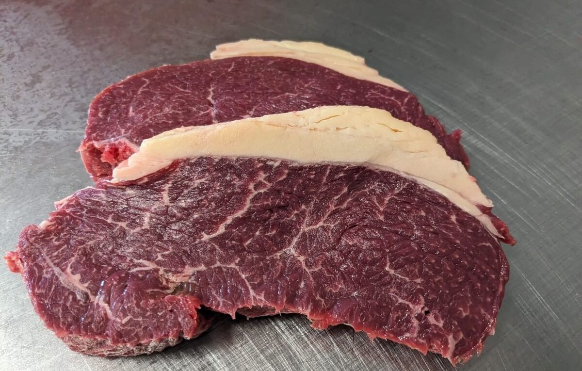 Rohe Rindfleisch-Zuschnitte auf dem Brett, bereit zum Grillen
